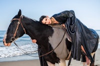 a woman riding a horse on the beach