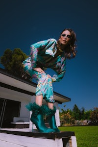 a woman in a colorful outfit standing on a wooden deck