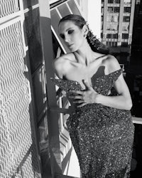 a woman in a black and white dress posing on a balcony