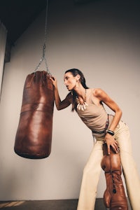 a woman is holding a boxing bag
