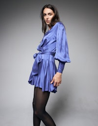 a woman in a blue silk dress posing for a photo