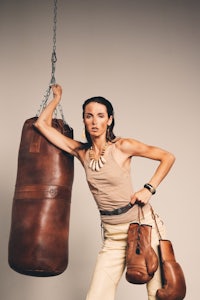 a woman is posing with a boxing bag