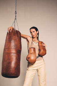 a woman is posing with a boxing bag
