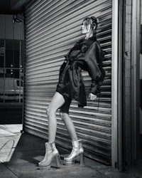 a woman is leaning against a garage door