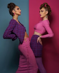 two women posing against a pink and blue background