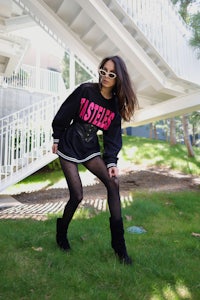 a woman wearing black tights and a black sweatshirt