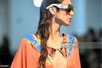 a model walks the runway wearing sunglasses during london fashion week