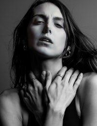 a black and white photo of a woman posing with her hands on her chest