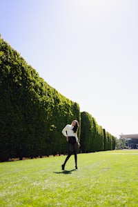 a woman is flying a frisbee in a field