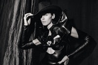 a black and white photo of a woman in a leather outfit